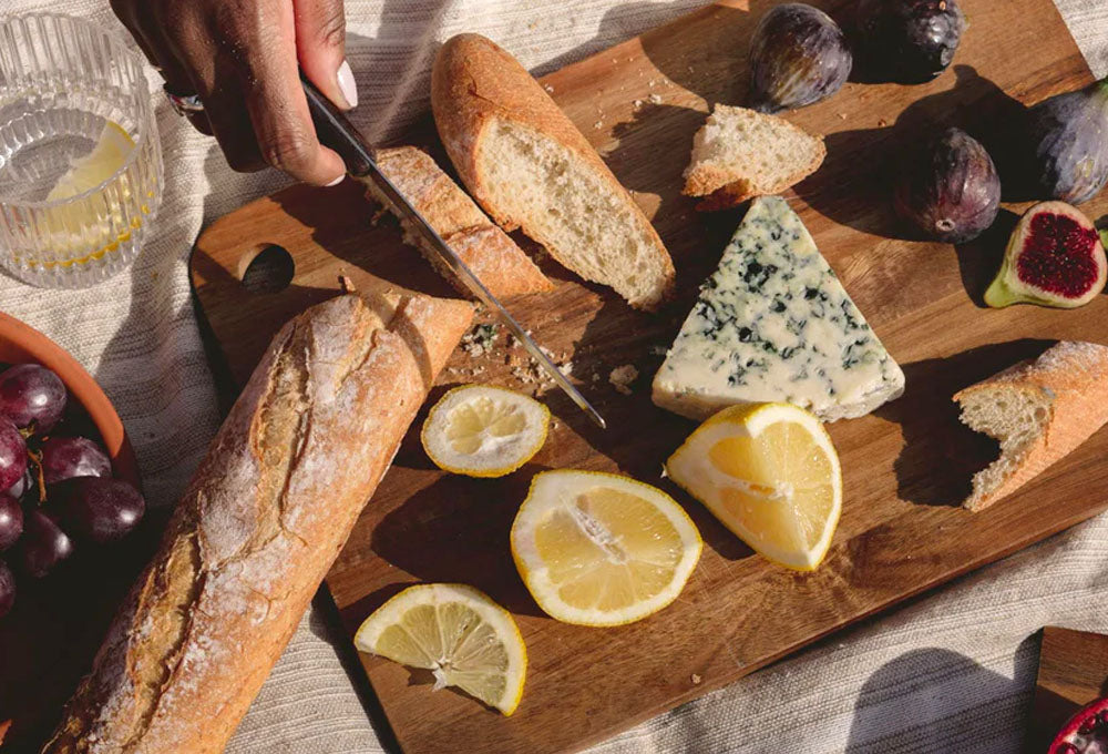 Smorgasbord of food - snacks of bread, cheese, lemons and figs.
