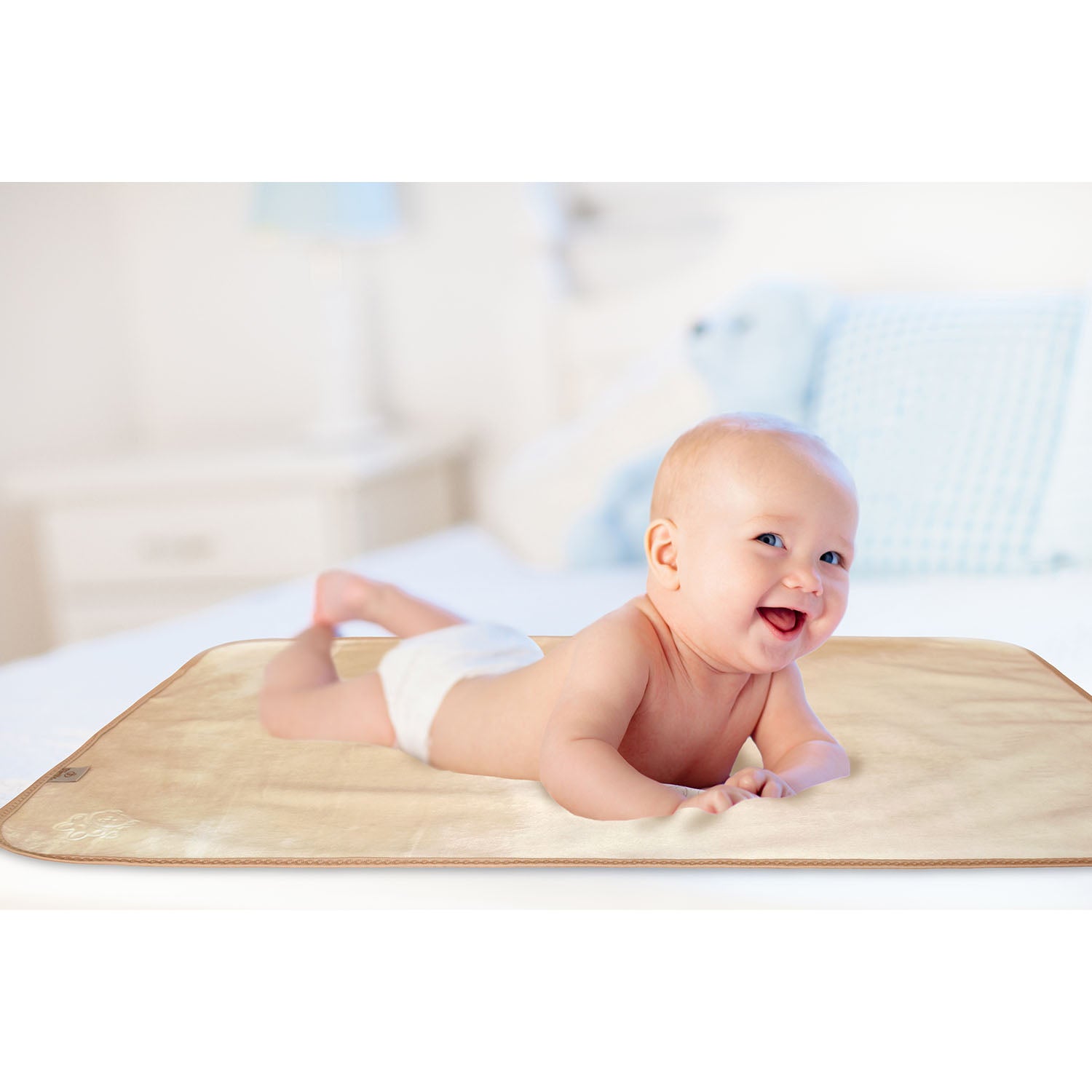 Happy baby lying on tummy on a soft waterproof Bibetta Plush tummy time mat in beige and cream