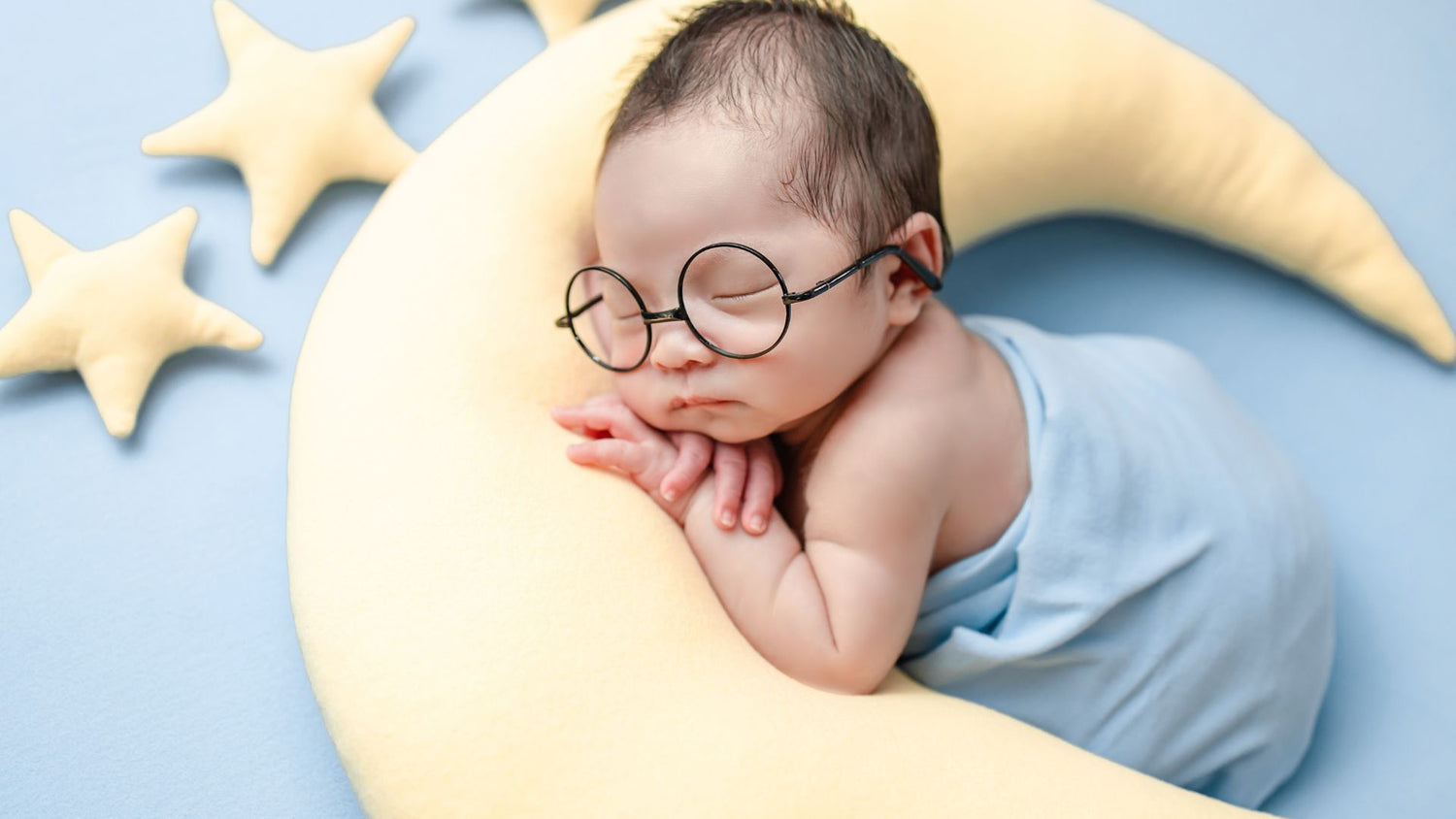 Baby sleeping  or napping on a moon shaped pillow