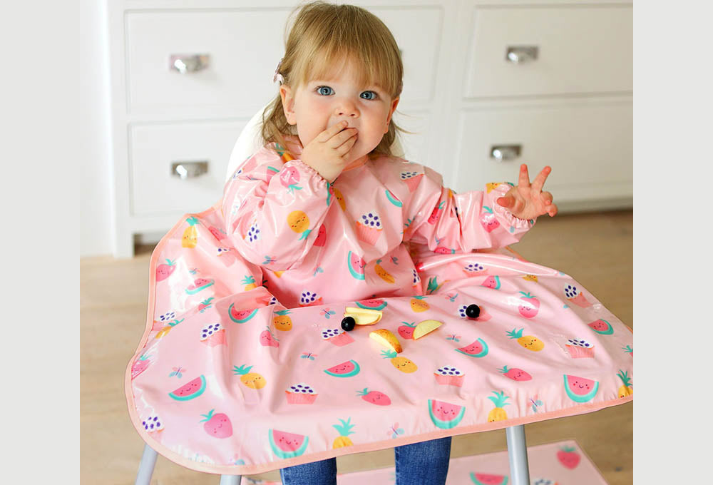 Bibetta pink Wipeezee Coverall Bib with girl eating fruit