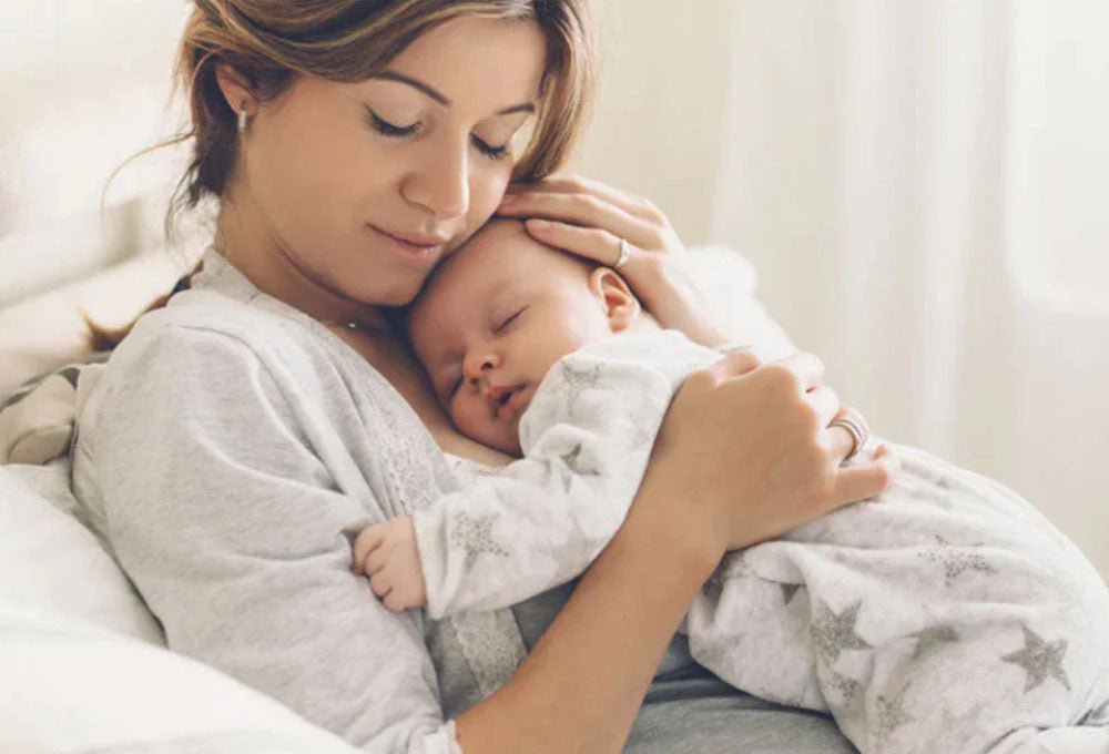 Mother with her baby asleep on her chest
