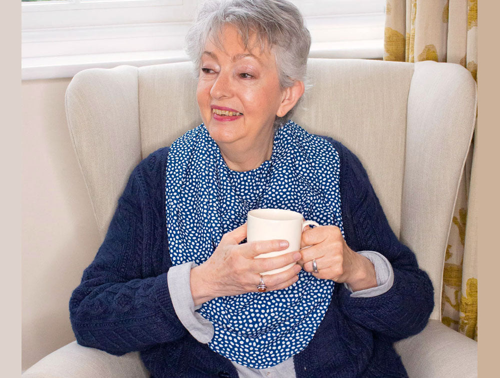 Bibetta and Care Designs Pashmina Scarf style adult bib in navy blue and white spots - dots. A stylish, elegant, dignified design, absorbent and with a waterproof backing.