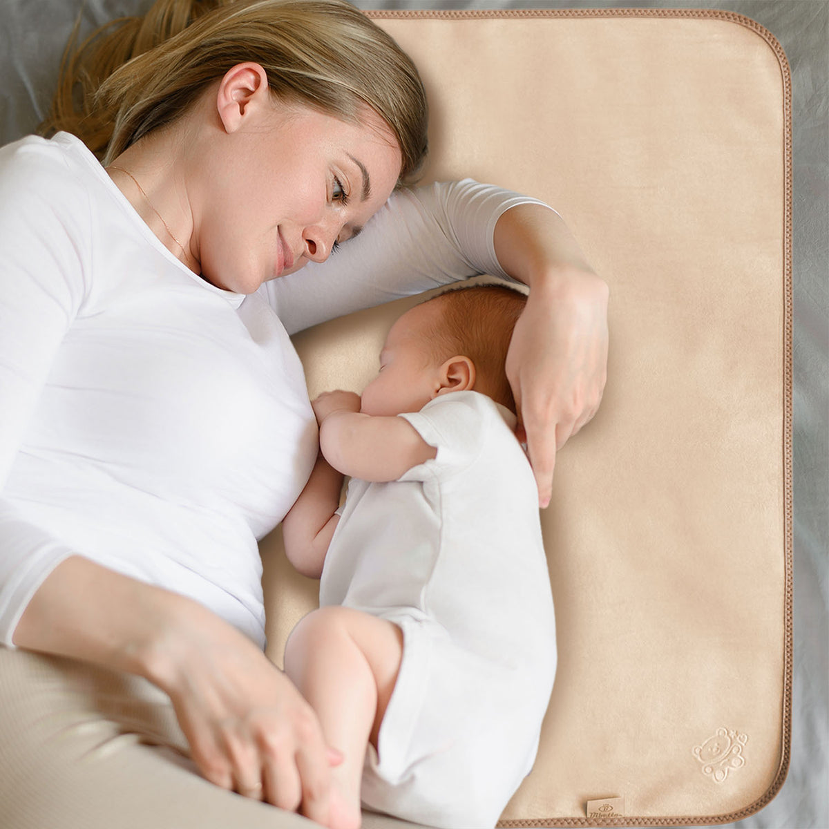 mother and baby both wearing white tops lying next to each other on a Bibetta Plush tummy time mat in cream and beige