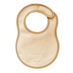 bibetta newborn plush cream and beige baby bib with a beige bias binding with a zig-zag stitch and a teddy embossed in the front on a white background