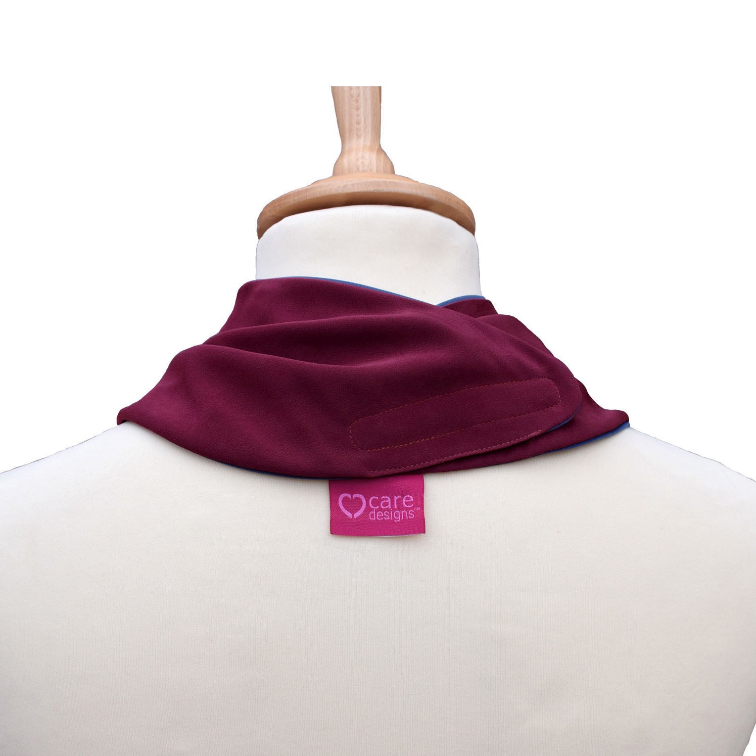Back view of a burgundy neckerchief bib on a mannequin with 'care designs' label