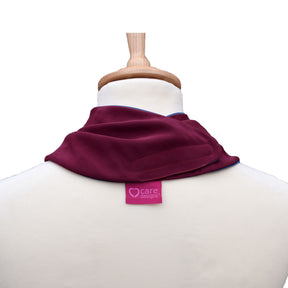 Back view of a burgundy neckerchief bib on a mannequin with 'care designs' label