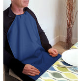Person wearing a Care Designs long navy napkin sitting at a table with a colorful tablecloth