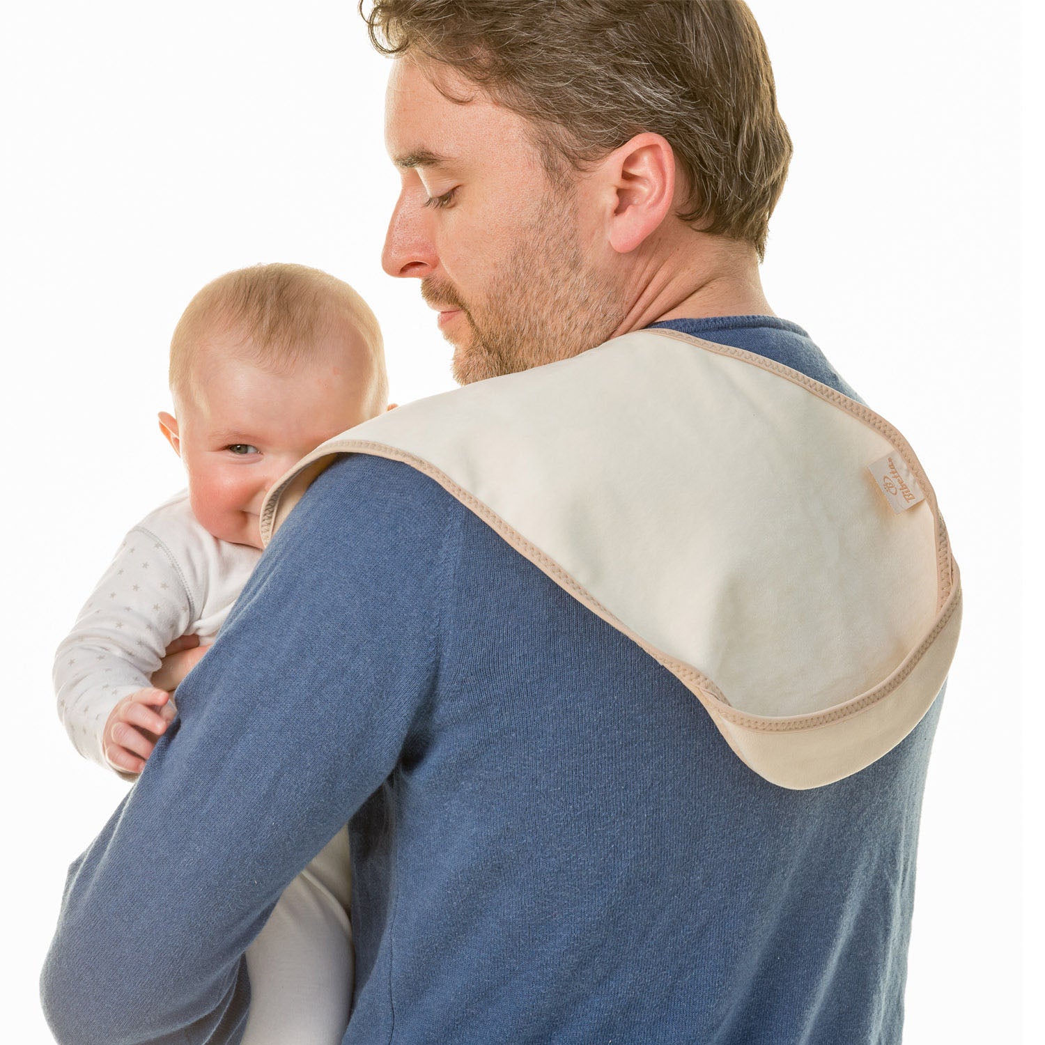 man with brown hair wearing a blue long sleeve top holding a baby in a white and grey spotted onsie with a Bibetta cream and beige burp cloth on his shoulder