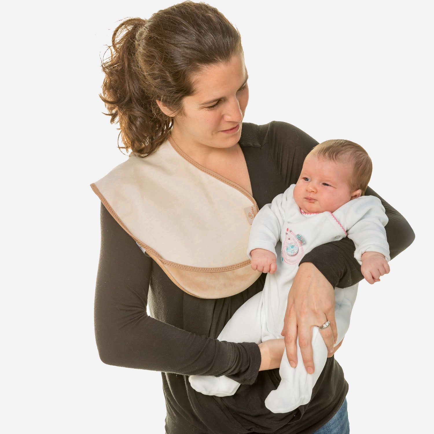 lady with dark hair up in a ponytail wearing a long brown t-shirt holding a baby in a white onesie with a Bibetta cream burp cloth on her shoulder