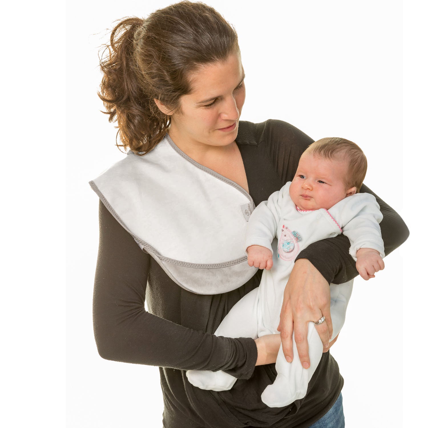 lady with dark hair up in a pnytail wearing a long brown t-shirt holding a baby in a white onesie with a Bibetta white burp cloth on her shoulder